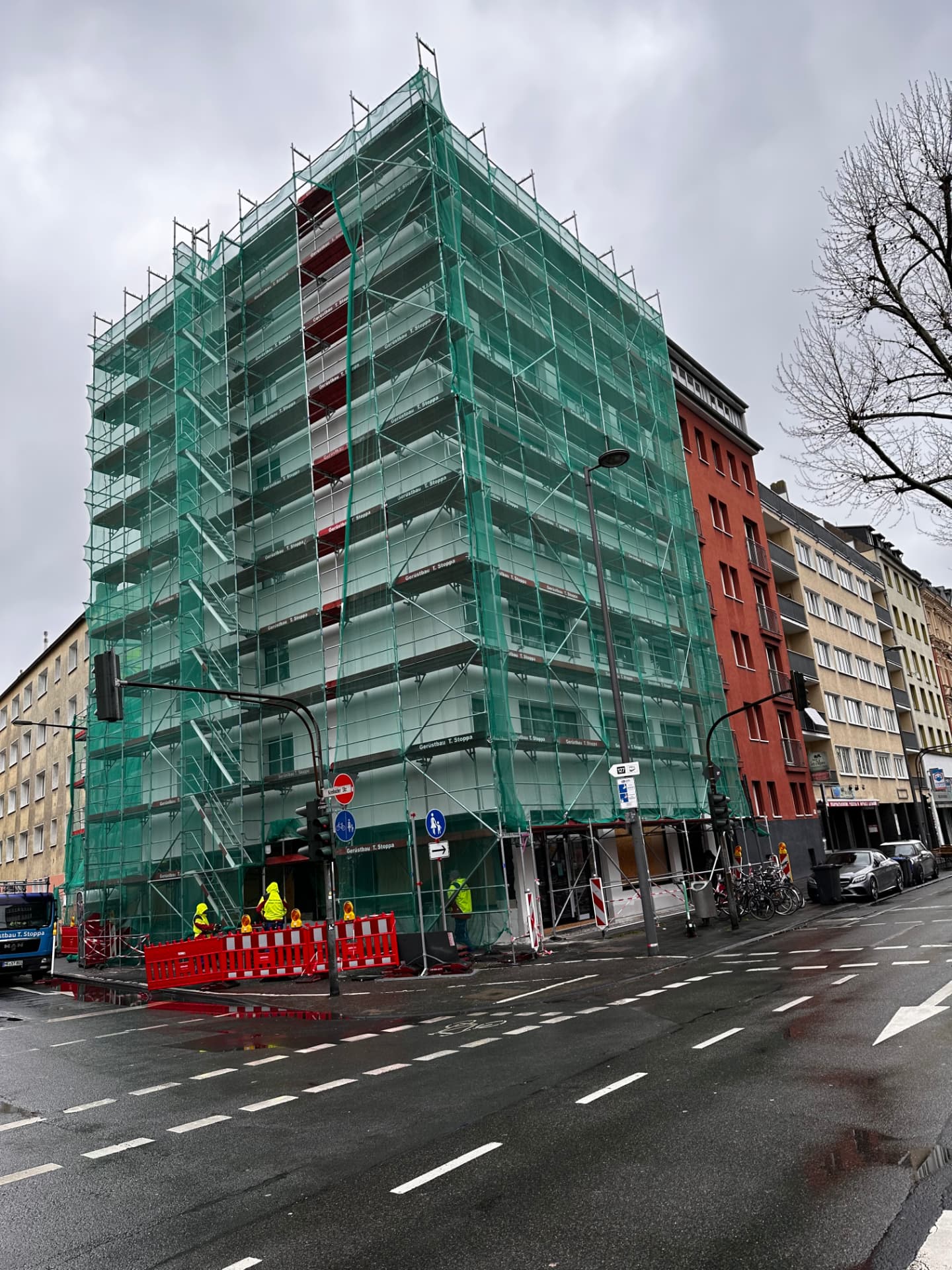Echtes Stoppa-Projekt: eingerüstetes Eckgebäude mit Schutznetz bei der Fassadensanierung